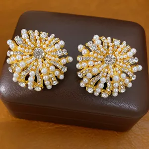 Nahaufnahme eleganter Blumen-Ohrstecker mit weißen Perlen und glitzernden Strasssteinen