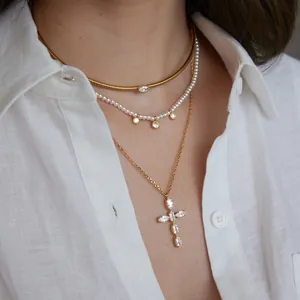 Gedetailleerd overzicht van gelaagde kettingen met parels en een marquise kristallen kruis