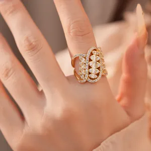 Luxury gold-plated ring with zircon inlay and ornate geometric pattern on a finger.