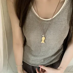 Detailweergave van een stenen vis hanger aan een leren koord ketting gedragen door model