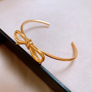Gros plan sur l'élégant bracelet jonc ouvert plaqué or 18 carats avec détail de nœud