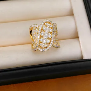 Detailed macro view of an ornate gold-tone ring encrusted with clear cubic zirconia