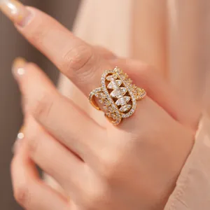 Close-up of golden geometric twisted ring with shimmering white zircon stones