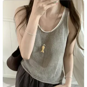 Detail van een minimalistische leren koordketting met een kleine stenen vishanger