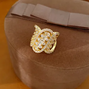 Detailed close-up of a gold-plated geometric twisted ring with sparkling zircon inlay