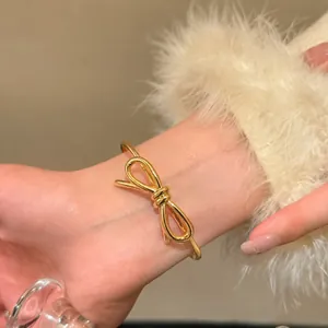 Gros plan détaillé d'un bracelet jonc ouvert avec nœud papillon plaqué or 18 carats