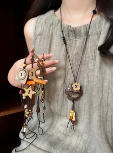 Detail of ethnic vintage beaded necklaces with star and moon wooden pendants on a model.