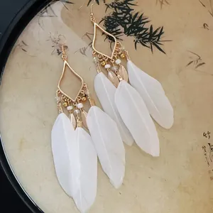 Vue détaillée de boucles d'oreilles style nouveau chinois avec plumes blanches et cadre doré