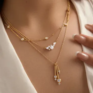 Vista detallada de un elegante collar de varias capas dorado con perlas y colgantes de CZ