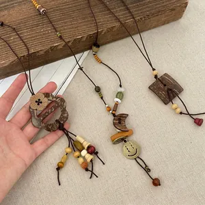 Detail of ethnic style long beaded necklaces with moon and flower wooden pendants.