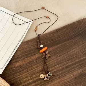 Close-up of vintage ethnic necklace with wooden star and moon pendants on a wooden tray
