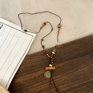 Close-up view of vintage ethnic style beaded necklace with moon and smiley pendants