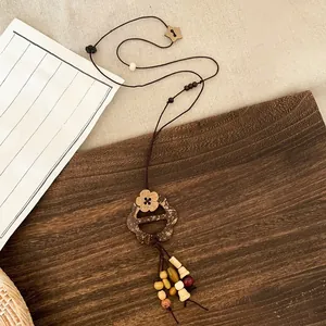 Close-up detail of the vintage ethnic style beaded necklace featuring a wooden flower pendant