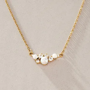 Primer plano de un elegante colgante de perlas y circonitas en cadena de acero dorado