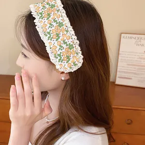Close-up of a sweet floral print headband with crochet lace trim on model