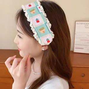 Close-up of a sweet mint green floral knit headband featuring elegant lace trim on a model