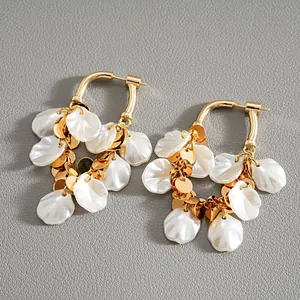 Vue détaillée de boucles d'oreilles ovales avec pétales en résine et paillettes dorées