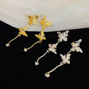 Elegant gold and silver tone butterfly tassel earrings with crystals on black velvet