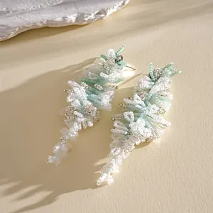 Gros plan élégant montrant la texture délicate des boucles d'oreilles à pompons perlés.