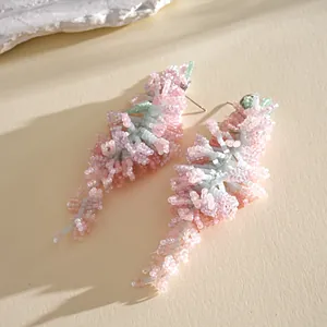 Vue détaillée des boucles d'oreilles artisanales à pampilles en perles roses et vertes