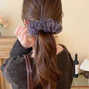 Detailansicht einer eleganten Haarspange mit Leopardenmuster auf einem hohen Pferdeschwanz