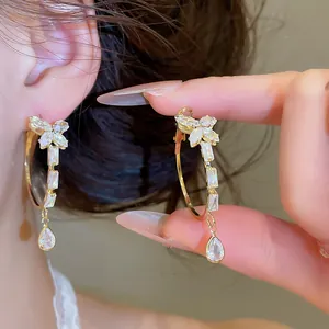 Elegante gouden creolen met fonkelende vlinder- en druppelvormige zirkonia-bedels.