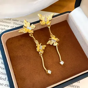 Macro-weergave van elegante gouden vlinder-oorbellen met kristallen in een doosje