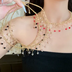 Close-up of gold lace choker necklace featuring vibrant red, black, and clear bead tassels.