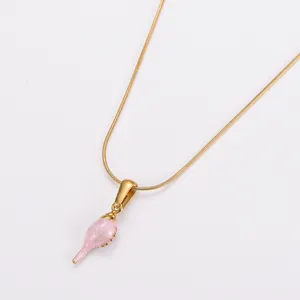 Detailansicht eines rosa glitzernden Muschel-Anhängers an einer goldenen Schlangenkette