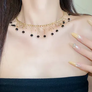 Detailed macro view of a gold lace choker necklace featuring elegant black beaded fringe tassels