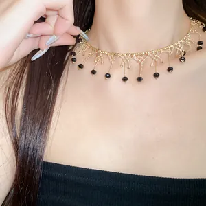 Elegant gold lace choker featuring sophisticated black bead fringe details shown on model neck.