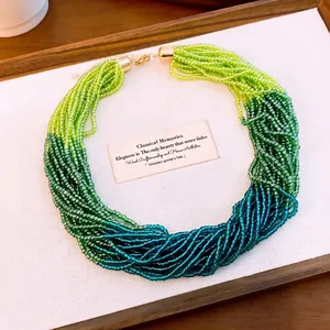 Elegante meerstrengs kristallen kralenketting met groen kleurverloop en gouden sluiting