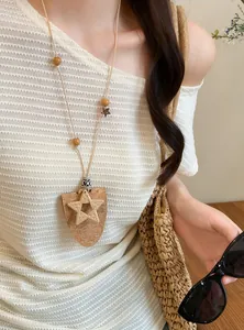 Detail van een bohemien kurk hanger ketting met geweven ster en verstelbaar leren koord.