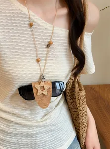 Detailopname van een leren koordketting met ster en functionele brillenhouderclip