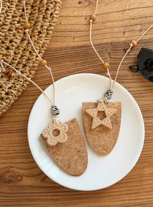 Gedetailleerd overzicht van boho-kettingen met kurken hangers en hars bloem/ster charms.