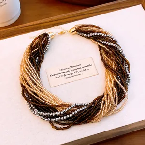 Détail d'un collier de perles de cristal multicouches avec perles ambre et argent.