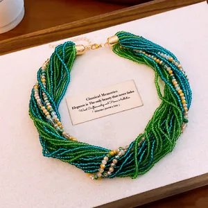 Gros plan d'un collier de perles de cristal multicouche bleu-vert avec un design torsadé