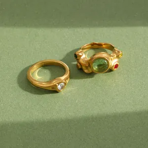 Gros plan de bagues irrégulières plaquées or 18 carats avec cristaux multicolores.