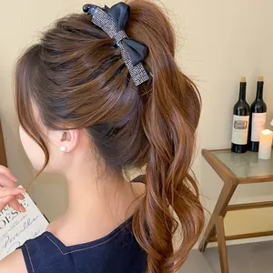 Élégante pince à cheveux avec nœud en strass portée en queue de cheval haute chic