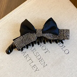 Gros plan d'une pince à cheveux noire à nœud ornée de strass élégants