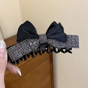 Vue détaillée d'une pince à cheveux élégante avec un nœud en strass noir et argent