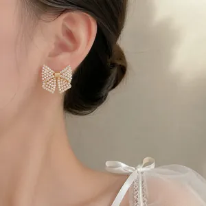 Elegante goldene Schleifenohrringe mit Kunstperlen und glänzenden Strasssteinen für Damen