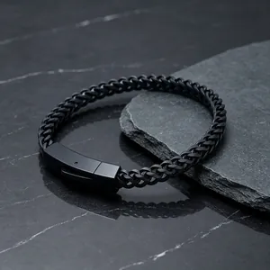 Macro view of black stainless steel wheat chain bracelet with secure square clasp.