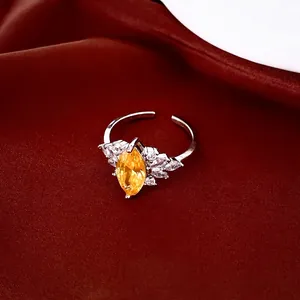 Elegant open ring featuring yellow marquise zircon and sparkling side stones on red silk.