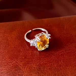 Anello aperto in argento con grande zircone ovale giallo e pietre laterali su pelle