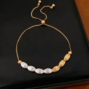 Detail shot of a vintage two-tone adjustable bracelet featuring textured gold and silver oval beads.