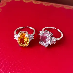Detail of yellow and pink oval zircon rings with silver-toned adjustable bands