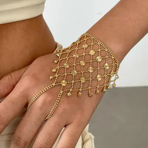 Detailed view of a gold geometric hollow slave bracelet with delicate tassel charms