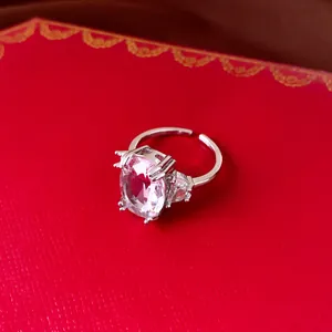Detailed macro view of silver adjustable ring with large oval pink zircon and side stones