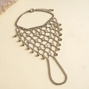 Detailed close-up of a silver geometric hollow hand chain bracelet with elegant tassels